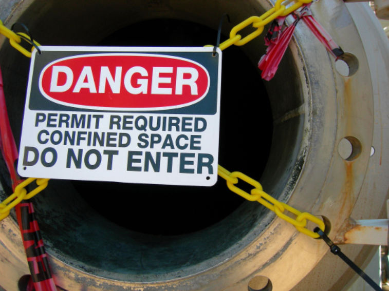 large tube with a sign in front of it that says "Danger"