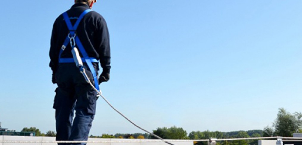 Person with back to the camera is tied off with a harness.