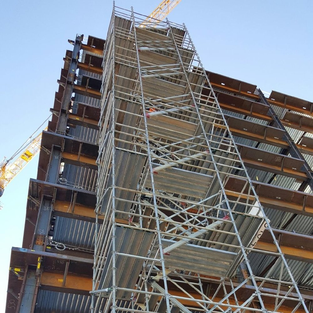 scaffolding going up a building under construction about 10 stories high